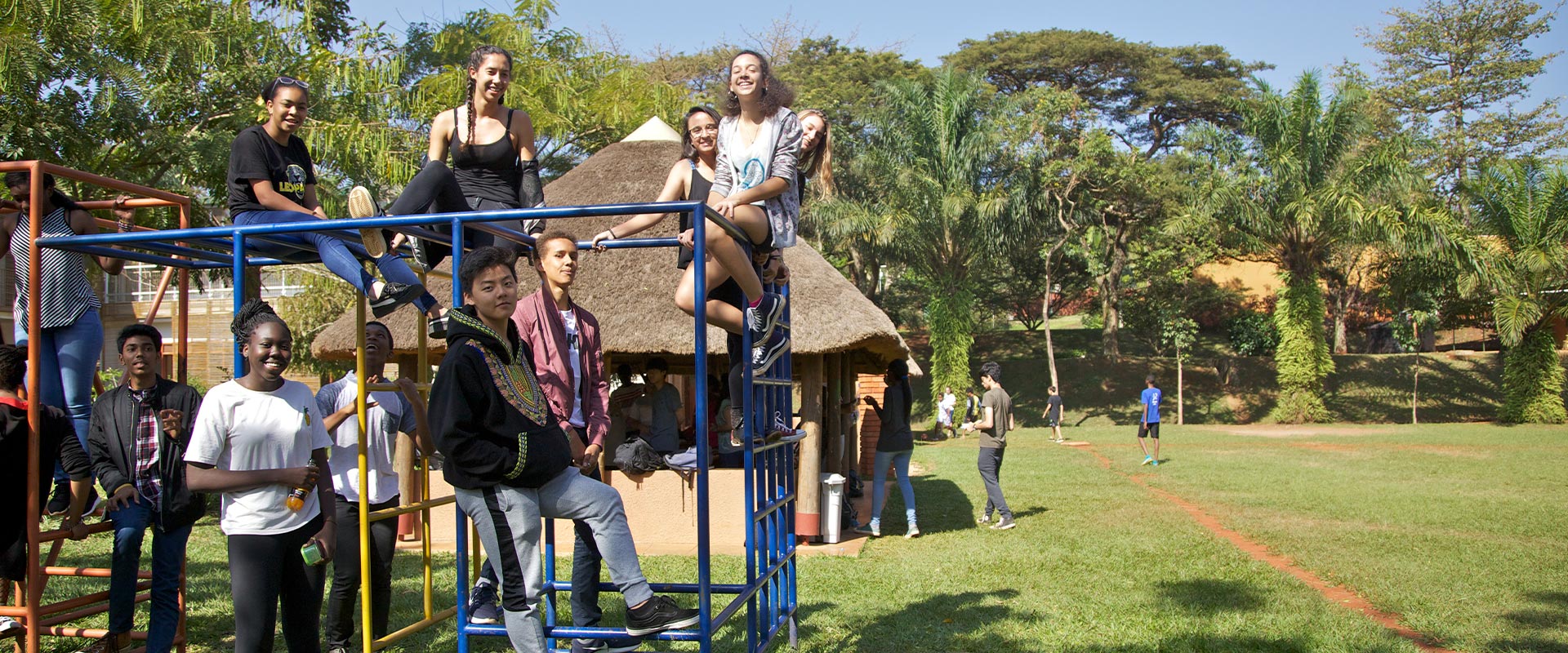 ISU alumni smiling and playing on a climbing frame