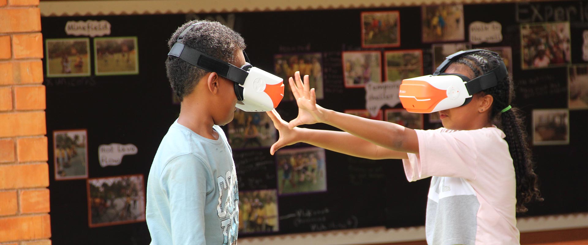 Two children with VR goggles on at the International School of Uganda