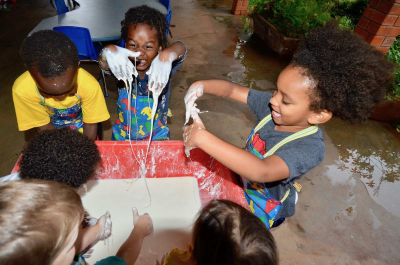 Children playing with cornstarch and water at ISU